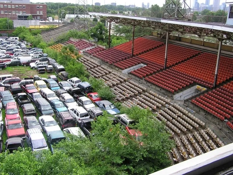 Bush Stadium during its use as car storage. Trees and vegetation are growing in the infield